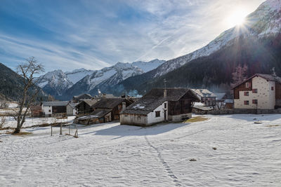 Houses on snow covered landscape against sky