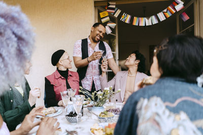 Portrait of smiling friends sitting on table