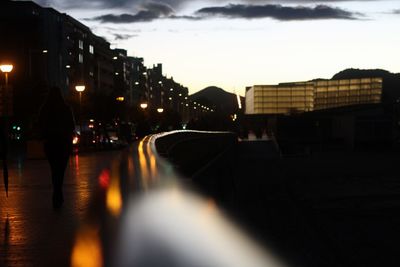 Illuminated city street against sky at night