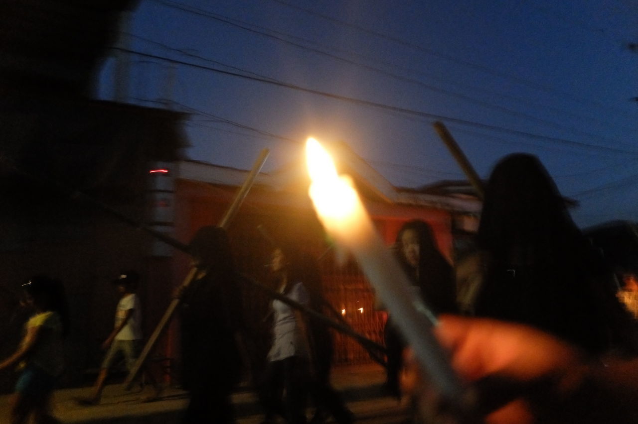 PEOPLE ON ILLUMINATED STREET AT NIGHT