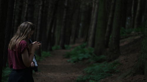 Woman smoking cigarette in forest