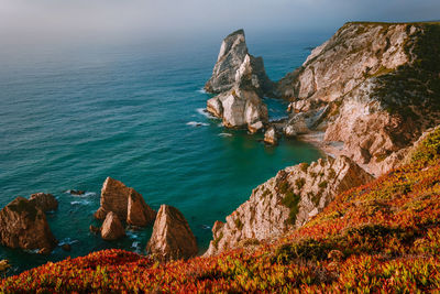 Scenic view of rocks in sea against sky