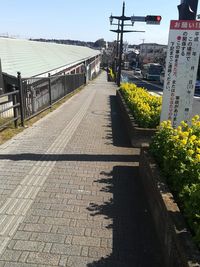 Walkway amidst buildings against sky