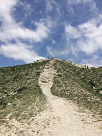 Low angle view of trail on hill against sky