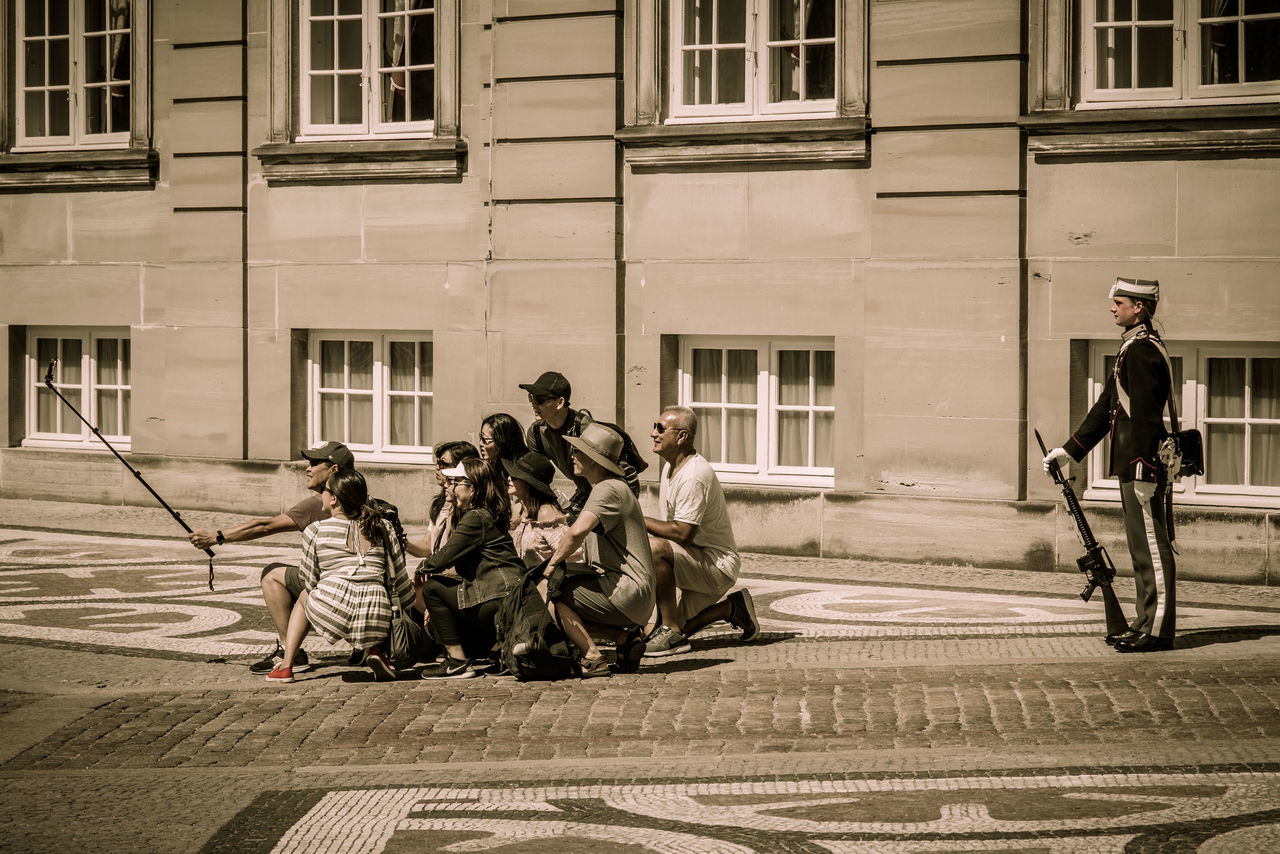 architecture, city, building exterior, men, group of people, street, full length, built structure, real people, transportation, adult, day, city life, women, people, group, lifestyles, medium group of people, road, activity, outdoors