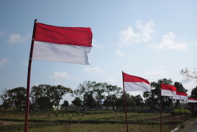 Red flag on built structure against sky