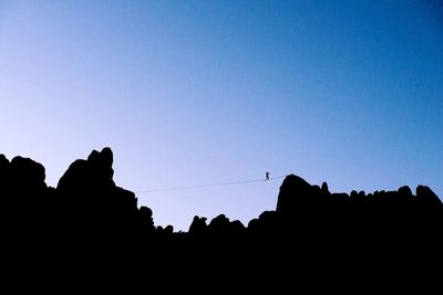 Low angle view of silhouette built structure against blue sky