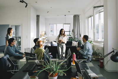 Female business professional conducting meeting with colleagues at office