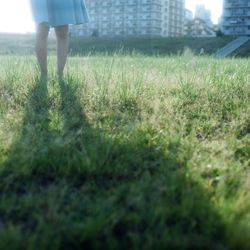 Low section of woman standing on grass