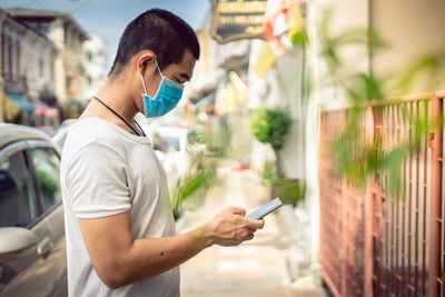 Side view of young woman using mobile phone