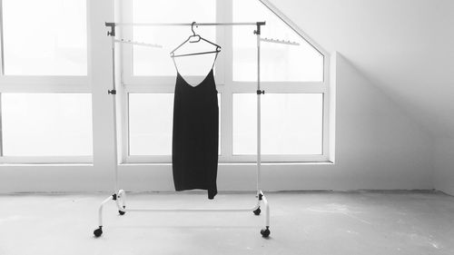 Black dress on hanger against the window