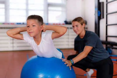 Children during physical activity class, exercising with fitness balls