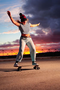 Full length of man standing by bicycle against sky during sunset