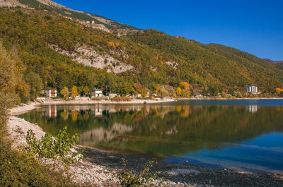 Scenic view of lake by buildings against sky