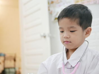 Close-up of boy with stethoscope at home