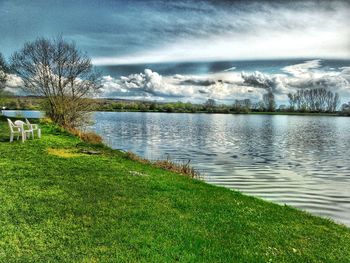 Scenic view of grassy field against cloudy sky