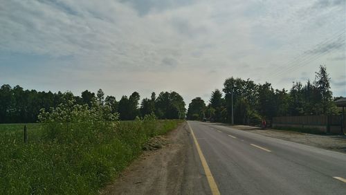 Road amidst trees against sky