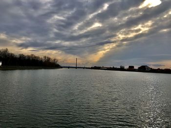 Scenic view of river against sky at sunset