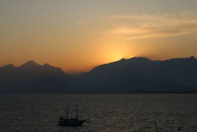 Scenic view of sea and mountains against sky during sunset