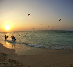 Silhouette of people on beach at sunset