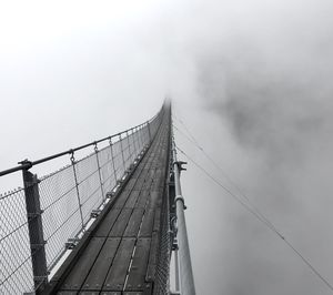 Low angle view of suspension bridge against sky