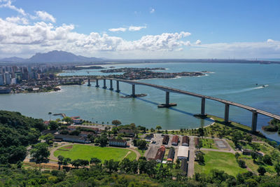 High angle view of city by sea against sky