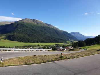 Road by mountains against sky