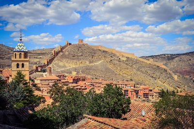 Town by mountains against sky