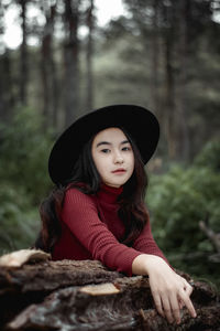 Portrait of woman wearing hat in forest