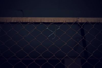 Close-up of chainlink fence against wall