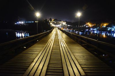 Footbridge over illuminated street at night