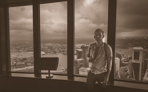 Man looking at cityscape through window