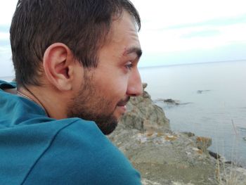 Close-up of man on beach against sky