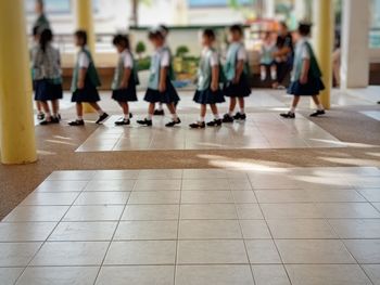 Group of people walking on tiled floor