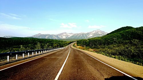 Empty road with mountains in background