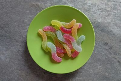 Directly above view of colorful gummy candies in plate on table