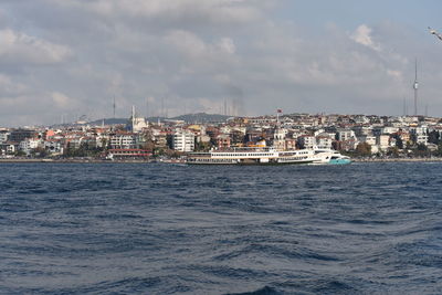 Sea by buildings against sky in city