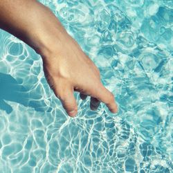 Low section of man relaxing in swimming pool