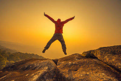 Full length of man jumping against sky during sunset