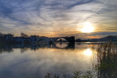 Bridge over river against sky during sunset