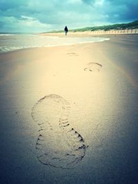 Low section of person standing on beach