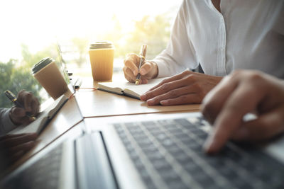Midsection of man using laptop on table