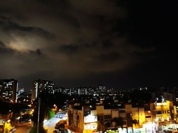 Illuminated cityscape against sky at night