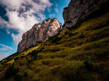 Low angle view of rocks on mountain against sky