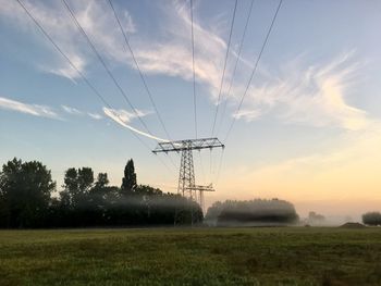 Electricity pylon on field against sky