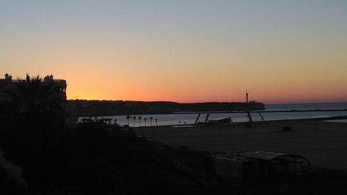 Scenic view of silhouette beach against sky during sunset