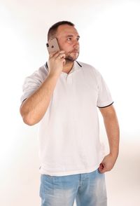 Young man looking away against white background