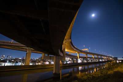 Low angle view of illuminated bridge against blue sky