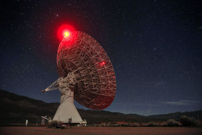 Low angle view of illuminated lighting equipment against sky at night