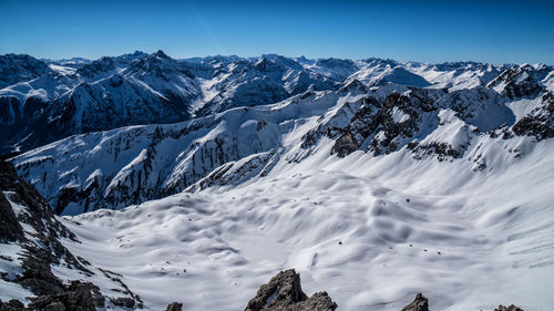 Scenic view of snow covered mountains against sky